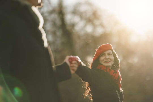 Couple Holding Hands in a Sunlit Park During a Winter Afternoon