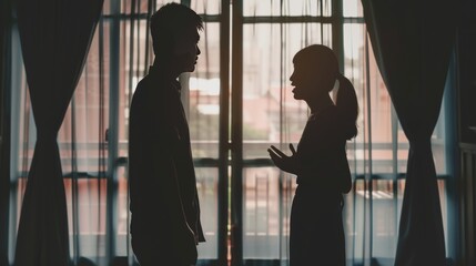 Silhouette of an Asian couple having a serious argument in front of a window at home, turning away from each other in frustration. - obrazy, fototapety, plakaty