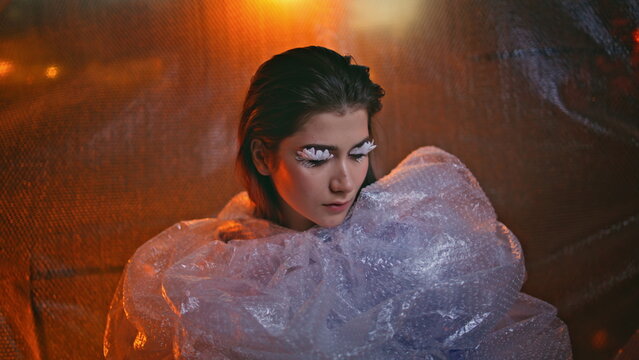 Closeup girl wrapped bubblewrap reflecting unique style. Woman petal eyelashes