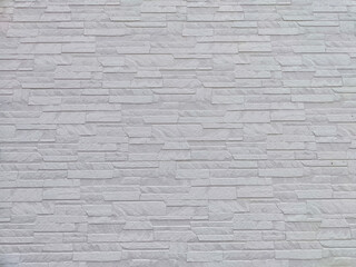 Fototapeta premium Uneven stones or bricks as a background and texture. Background, texture, pattern, frame, copy space. Close-up view of a wall with uneven stone bricks