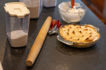 A chocolate Meringue Pie, freshly baked, ready to be served, placed on the counter with the raw ingredients that are in the pie. 