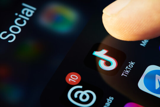 TikTok app icon on smartphone screen with other social media apps. Finger touch the icon of the TikTok application to run. Short video blogging. Shallow DOF, Moscow, Russia