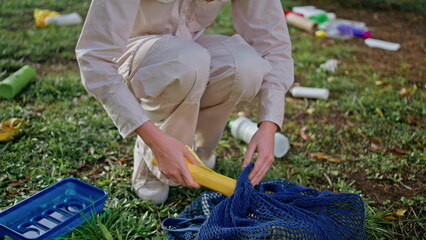 Woman hand plastic bag at cleanup action in green park closeup. Eco volunteer