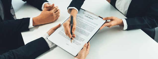 Business executive signing contract agreement document on the bale with the help from company...