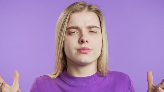 Annoyed young woman or stressed teenager girl holding head, fail time, conflict. Despair reaction on violet background.