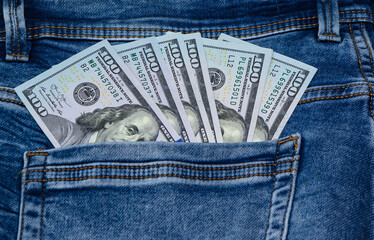 One hundred dollar banknote money in pocket jeans pants background texture. 100 dollar bill close up 1