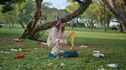 Girl park pollution cleanup collecting plastic organic waste from green grass. 