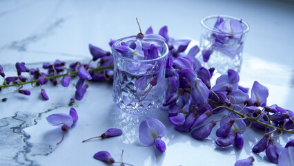 glasses with water and purple flower called lilac flowers