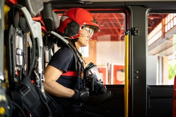 An adult Caucasian woman works as a firefighter dressed in uniform.The senior woman is sitting in...