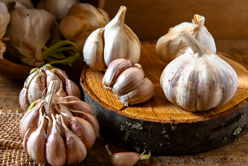 Organic garlic on rustic decorative wooden disc. Food background.