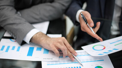 Businessman working at office desk, he is building a growing financial graph using wooden toy...