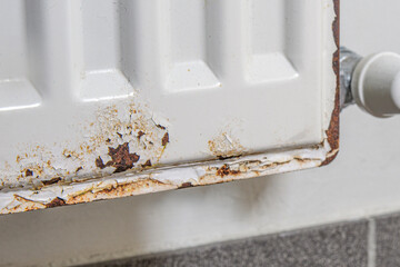 Close up of a corrosion on the metal surface of a heating radiator in a room