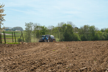 The spring sowing season. The ground is plowed by a tractor