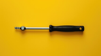 A black screwdriver against a vibrant yellow backdrop. Ideal for DIY or construction projects