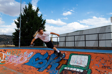 A man is skateboarding on a ramp with graffiti on the wall