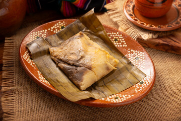 Oaxacan Tamale. Prehispanic dish typical of Mexico and some Latin American countries. Corn dough wrapped in banana leaves. The tamales are steamed. - 793262189