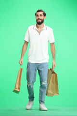 A man, full-length, on a green background, with bags