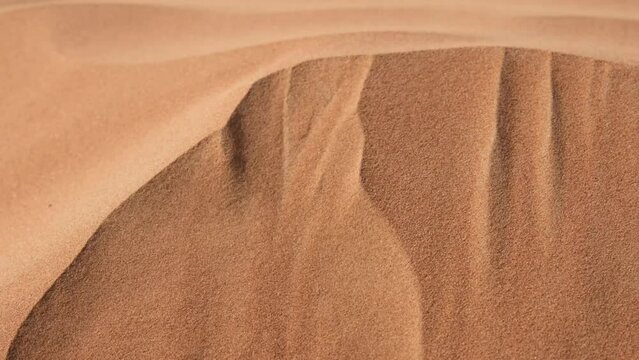 Movement of grains sand on dunes in desert from wind. Changing relief of sand dunes