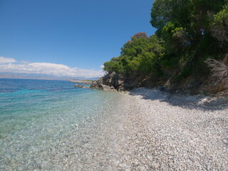 Secret beach in corfu island, Greece.  view to pristine beach with rocky bay and waves crashing