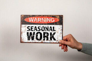 Seasonal Work. Warning sign with text in hands on light background - 793269793