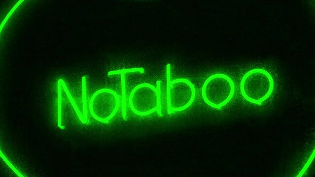 Peccability and amorality of society, decline in morals. No Taboo inscription in green color at sex shop window