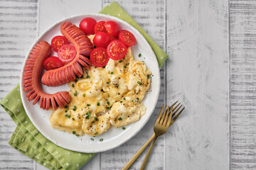 Scrambled eggs, sausage, and tomatoes on a white plate a hearty dish