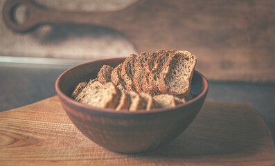Baked rye crackers in a clay plate on a wooden board