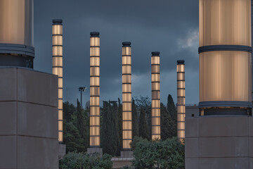 Columnas de luz dorada en la hora azul en Montjuic, en Barcelona, España. - obrazy, fototapety, plakaty