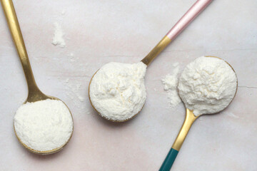 White powder in the spoon. Collagen protein powder or wheat flour. Concept of nutritional...