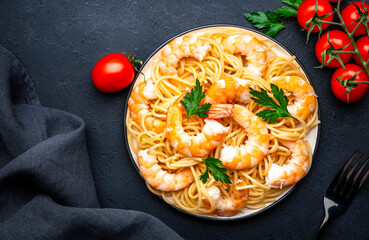 Ready for eat pasta with shrimp, olive oil and parsley on black table background. Top view - 793287957