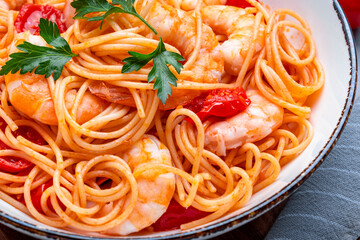Cooked Italian spaghetti pasta with shrimp and tomato sauce, gray table background, top view - 793288344