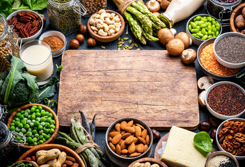 Vegan food background with copy space wooden cutting board. Plant protein., vegetarian nutrition sources. Healthy eating, diet ingredients: legumes, beans, lentils, nuts, soy milk, tofu - 793288708