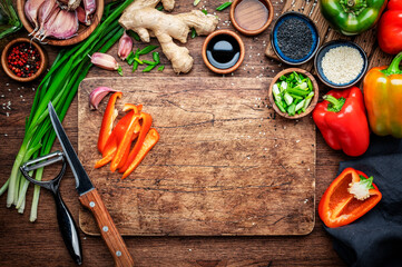Food and cooking background. Wooden cutting board with chopped vegetables, spices and ingredients for preparing vegetarian Asian dishes with mushrooms and soy sauce. top view, copy space - 793288721