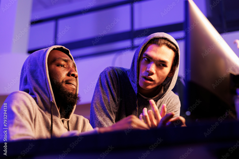 Poster hackers collaborating while discussing criminal activity and planning cyberattack. african american 