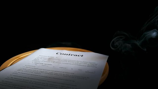 False agreement. A view of contract papers with false data lay on the table in smoke on the black background.