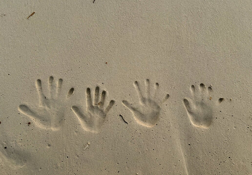 huellas de manos de una familia sobre la arena en una playa tropical. Holidays concept