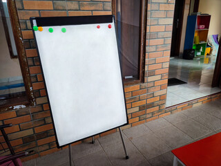 Mini blank white board for studying in front of red brick wall