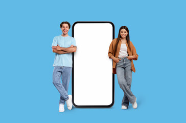 Young man and woman beside large smartphone mockup