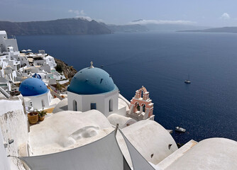 Aerial view of Oia town on the rocky shores of Santorini island - obrazy, fototapety, plakaty