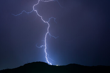 blue and bright lightning bolt in the sky above the mountains