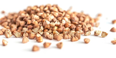 A pile of nuts with some of them broken open. The nuts are scattered on a white background - obrazy, fototapety, plakaty