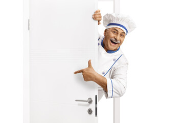 Mature chef in a uniform poitning at a door