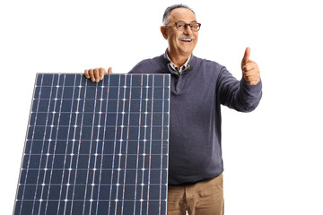 Mature man behind a solar panel smiling and gesturing thumbs up