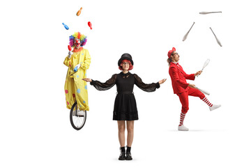 Female magician standing in front of a clown and juggler