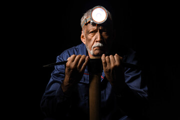 Mature miner man with pick axe on black background