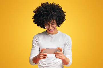 Cheerful young man watching video on cellphone