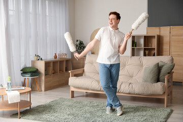 Young man having fun with pp-dusters in living room