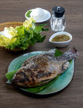 Tilapia grilled with vegetable on a wooden table