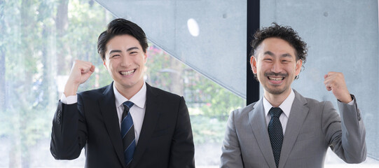 ガッツポーズをするビジネスマン2人　カメラ目線のバナー