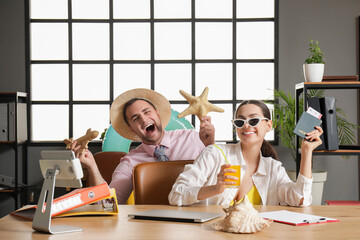 Happy office workers with starfish and passport at table in office. Summer vacation concept